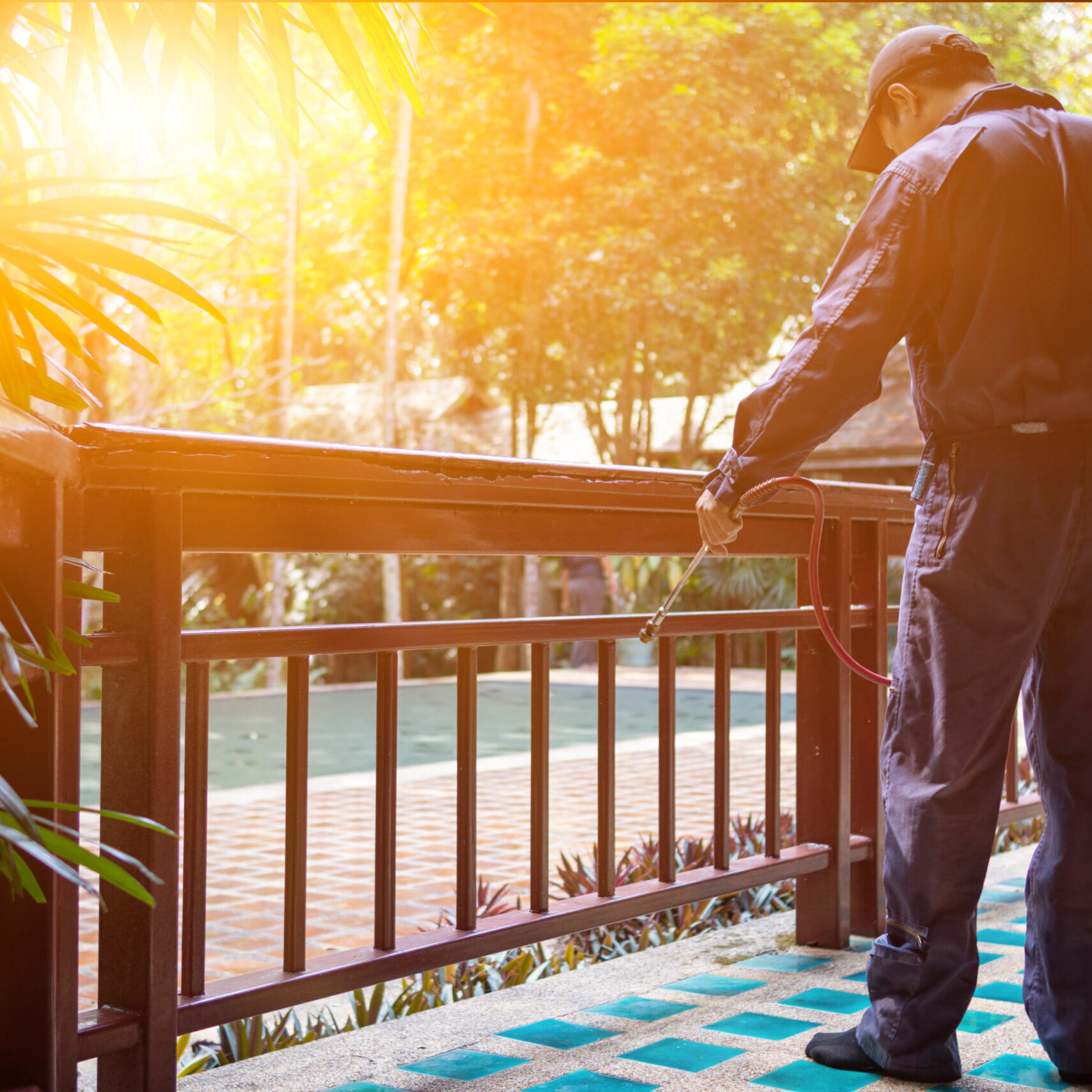 exterminate termite control company employee is using a termite sprayer at customer's house and searching for termite nests to eliminate. exterminate control worker spraying chemical insect repellant